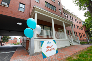 balloons and grand opening sign in front of an affordable housing development