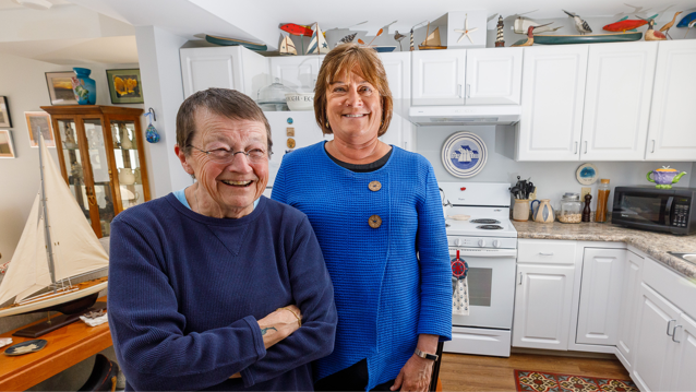 senior female affordable housing resident standing next to female banking professional