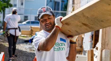 man holding a large piece of plywood