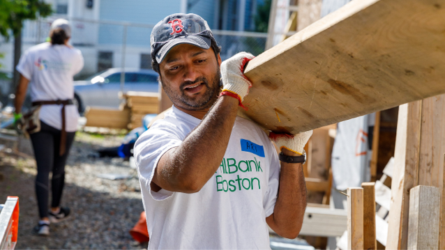 man holding a large piece of plywood