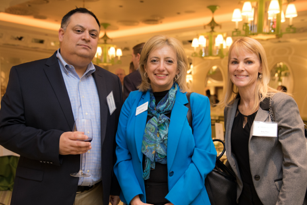 man standing next to two women as all three posing for a photo