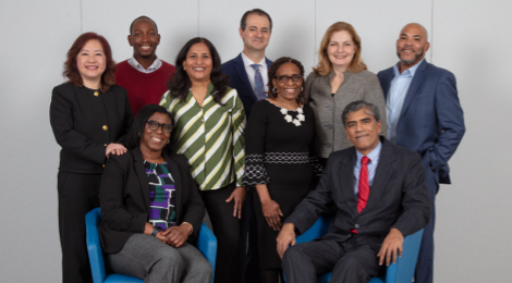FHLBank Boston female and male employees seated next to each other with four female employees and three male employees standing behind them