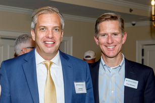 Two men wearing suit jackets standing next to each other smiling