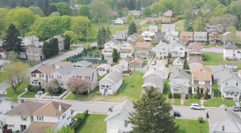 aerial view of homes in a neighborhood with trees and green grass