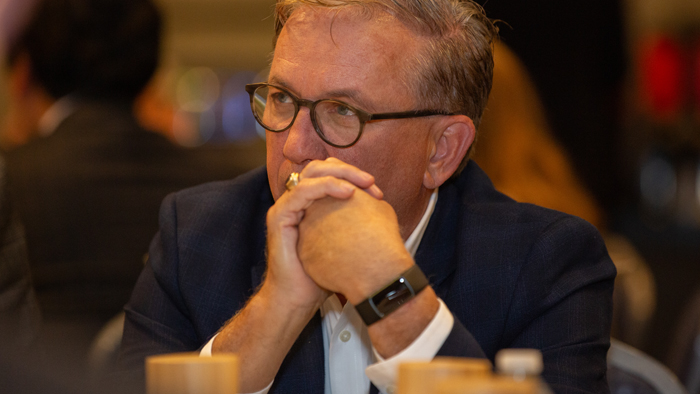Man wearing glasses holding his hands in front of his face
