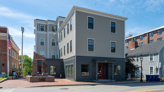 exterior of an apartment building with a flag pole and statute at the front in downtown Portsmouth, New Hampshire
