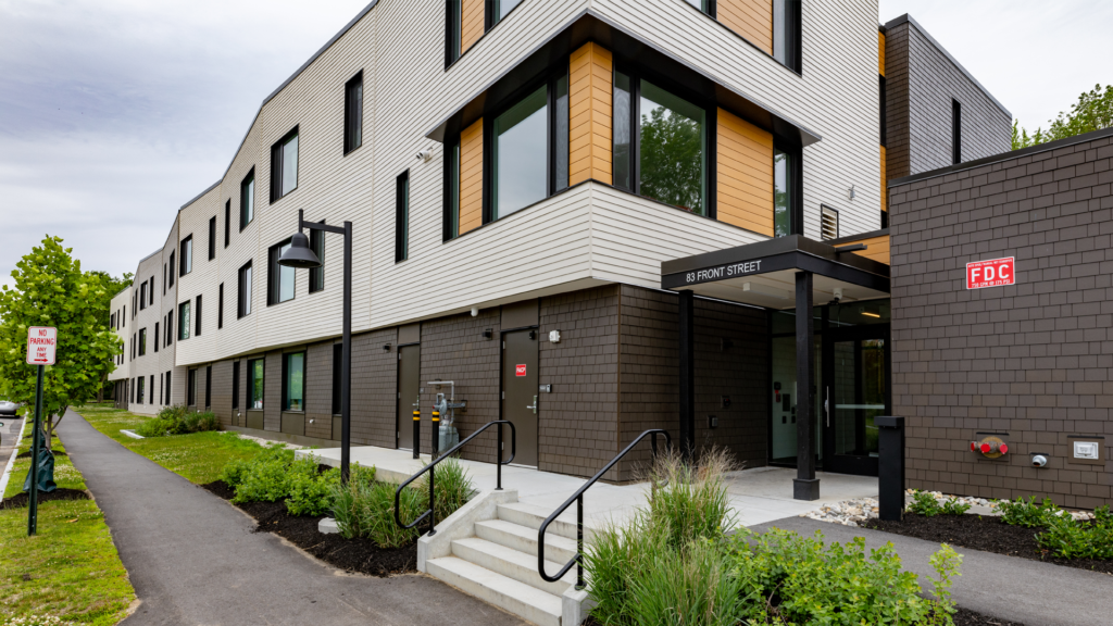 exterior of apartment building with greenery and steps leading to covered entry way with 83 Front Street