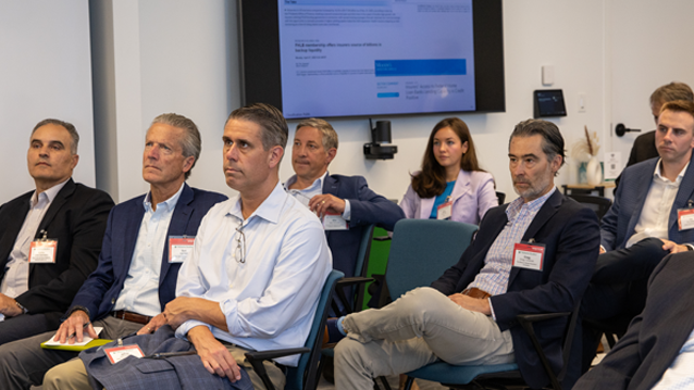 Group of insurance company representatives seated in a conference room during an FHLBank Boston meeting. A presentation is displayed while attendees listen and participate in the session.