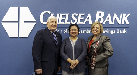 male bank leader with two women posing in front of Chelsea Bank logo